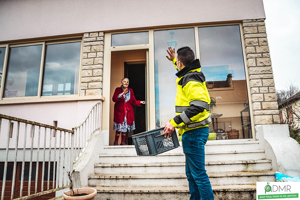 Livreur avec caisse dit au revoir personne agée